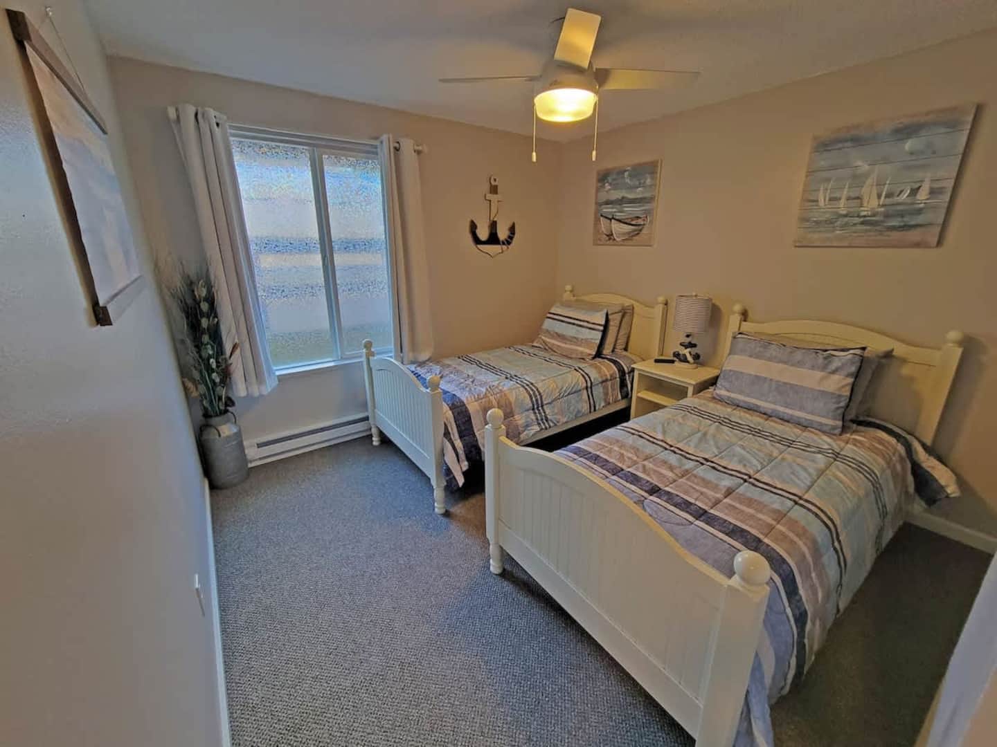 Discover the cozy bedroom with twin beds, designed in a seaside theme that will transport you to the tranquil shores with every dreamy slumber. Dive into a coastal experience!